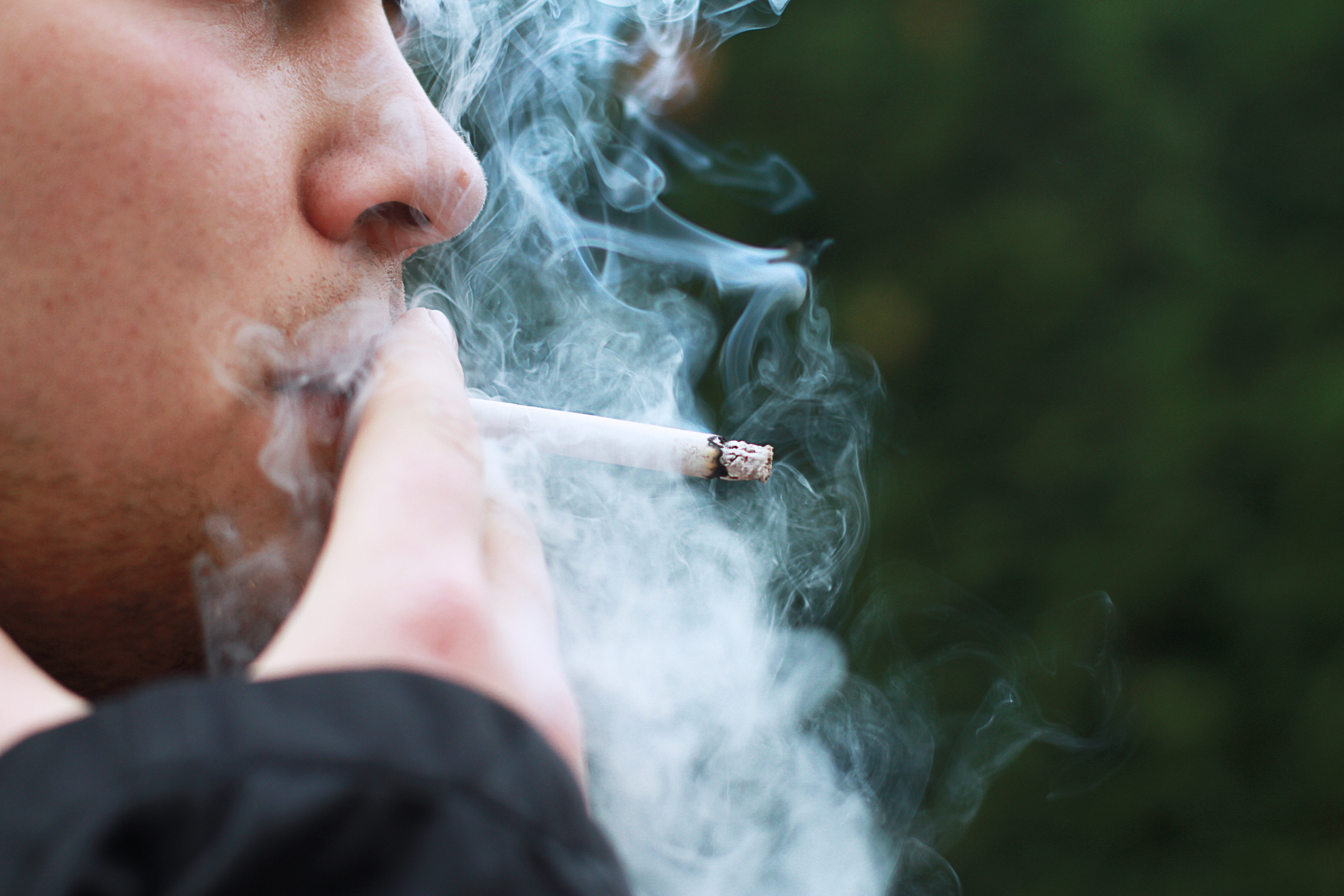 une personne fume une cigarette