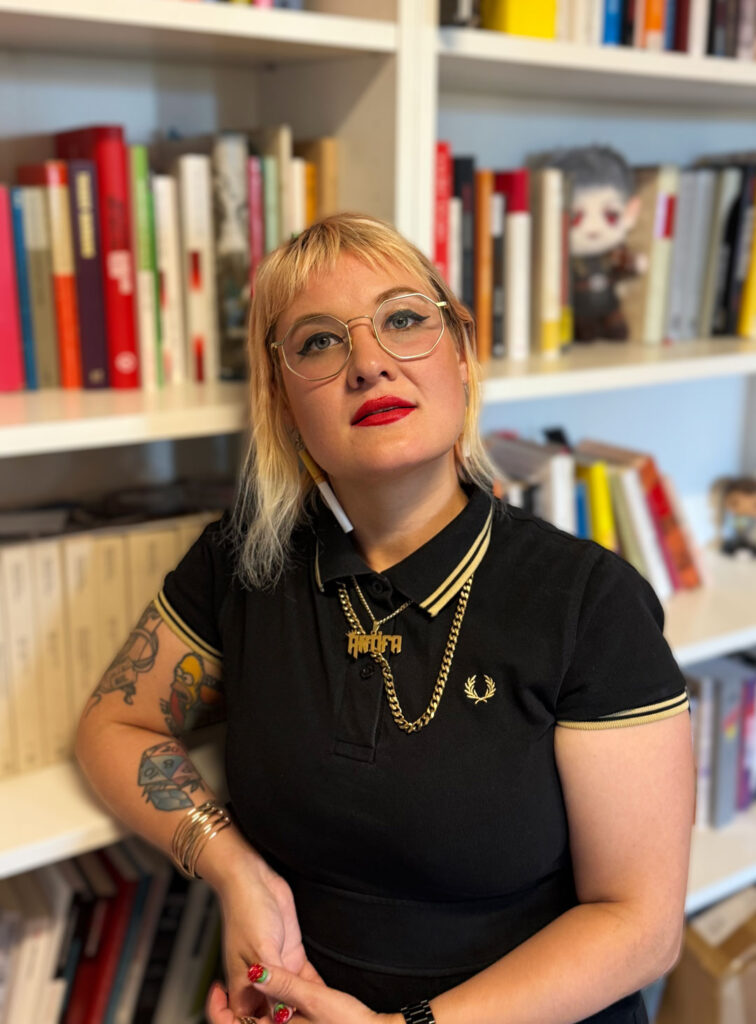 Die Autorin Veronika Kracher vor einem Bücherregal.