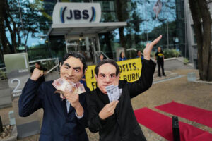Deux hommes face au bureau de jbs, manifestation des activistes de greenpeace.