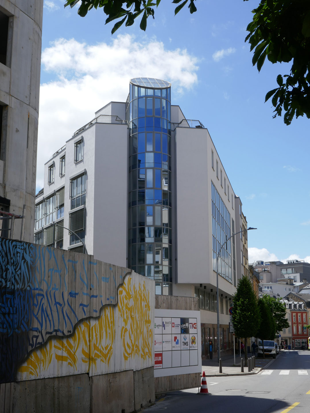 Un bâtiment en verre et béton – le futur centre de filtrage, rue Bender à Luxembourg – s’élève vers le ciel.