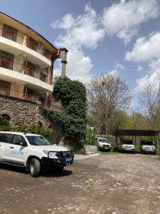 Ein weißer Geländewagen der Unicef steht vor einem Gebäude. Im Hintergrund sind weitere Fahrzeuge zu sehen.