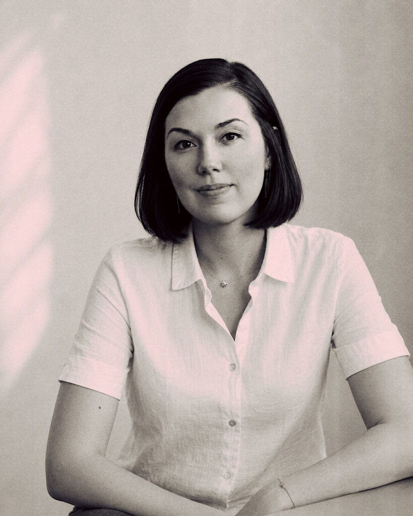 Portrait en noir et blanc d’une femme, cheveux courts, elle sourit.