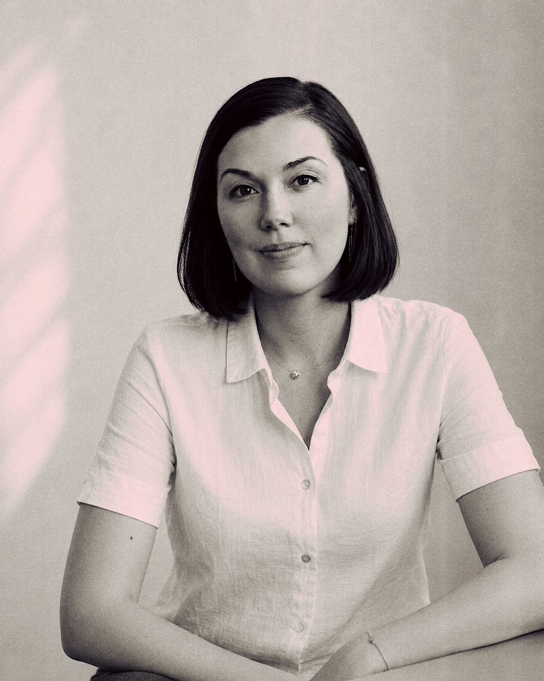 Portrait en noir et blanc d’une femme, cheveux courts, elle sourit.