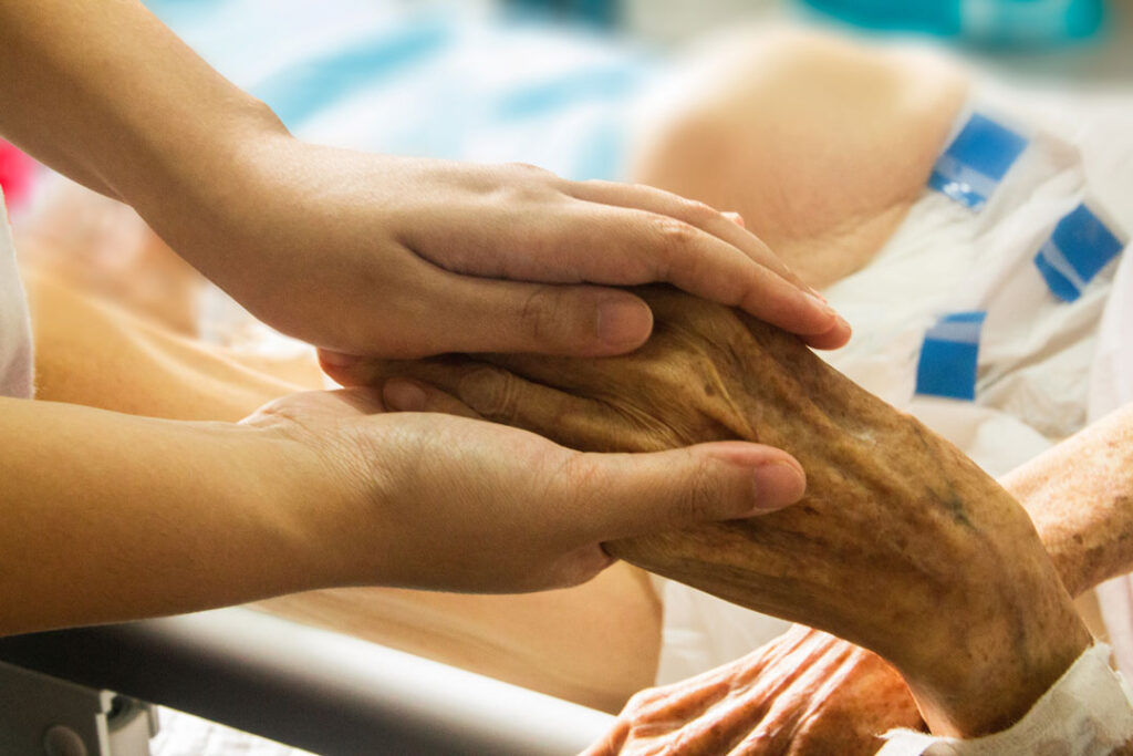 deux mains enserrent une main marquée par l’âge